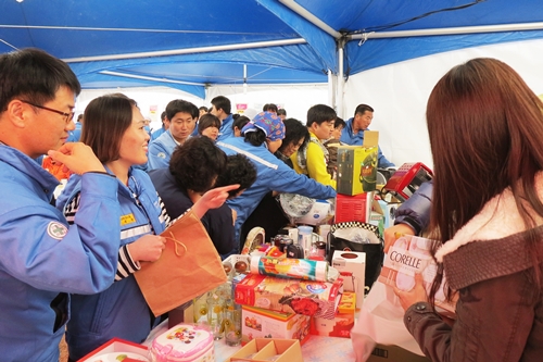 바자회 생활용품 코너에서 포스코켐텍 임직원이 물건을 살펴보고 있다.