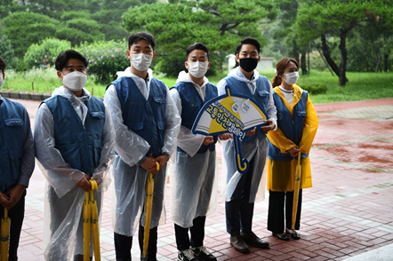 안전한 교통문화 정착을 위해 학교 앞에서 진행된 교통안전 캠페인  (가운데 우산 제작물을 든 사람이 황보혁 책임연구원)