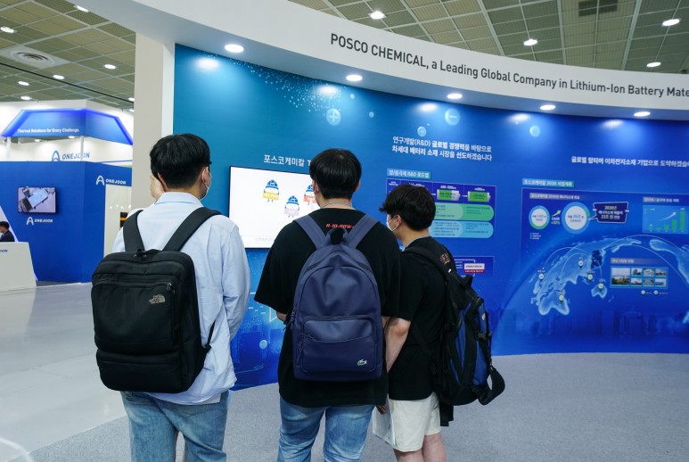 관람객들이 이차전지소재 원리를 쉬운 설명과 일러스트로 풀어낸 &lsquo;포스코케미칼 양극재 음극재 이야기&rsquo;를 시청하고 있다.