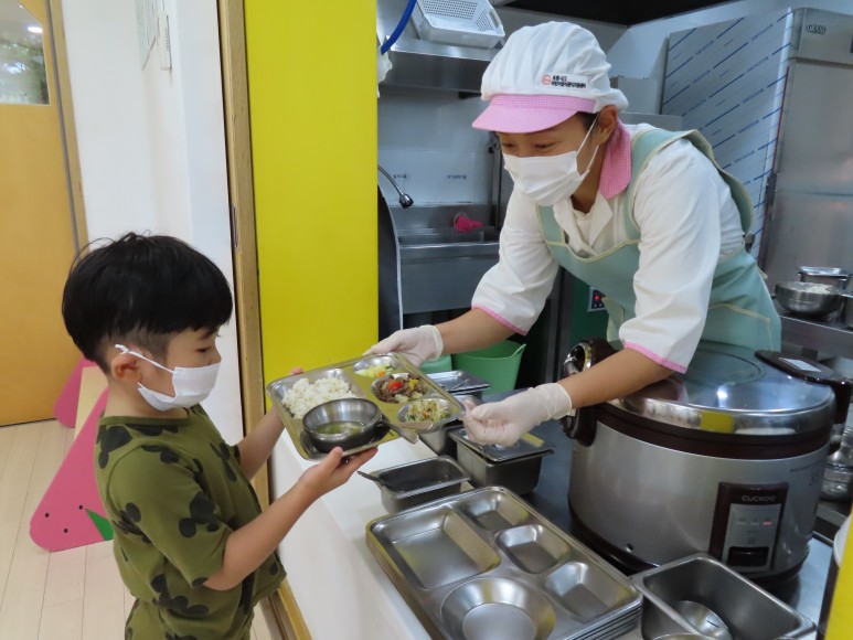 조리선생님이 정성껏 만들어 주신 점심식사를 받고 있는 원아 모습