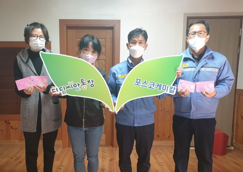 포스코케미칼 이태희 기업시민사무국장(왼쪽에서 세번째)과 김병우 팀장이 보호시설 관계자들과 디딤씨앗통장을 들고 기념사진을 촬영하는 모습