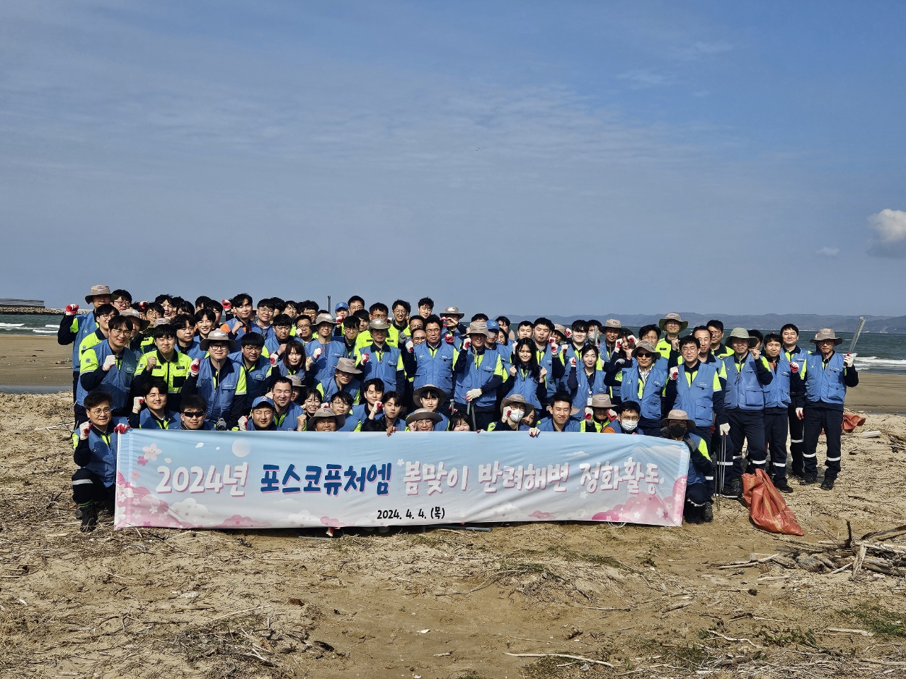 포스코퓨처엠 임직원들이 4일 반려해변인 포항 청림해변에서 해양쓰레기 수거 활동을 펼친 뒤 기념촬영하고 있는 모습