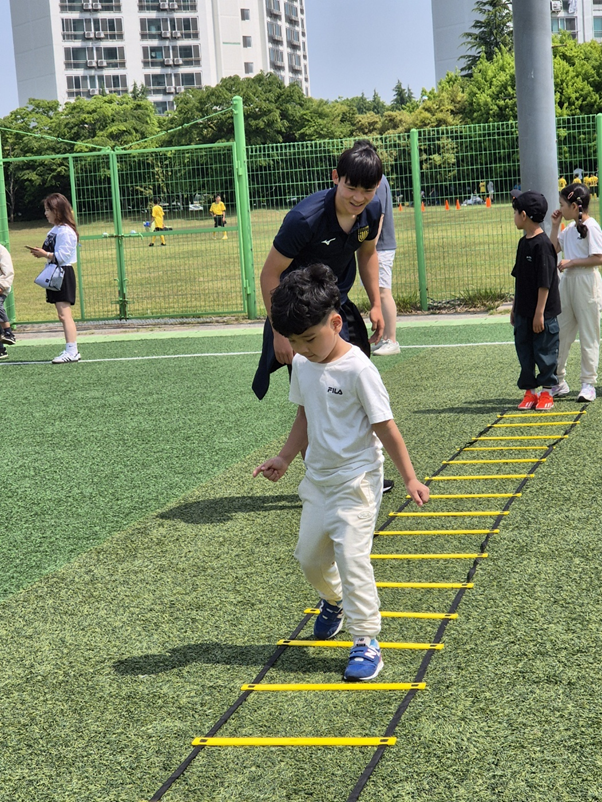 포스코퓨처엠 광양양극소재실 임직원들이 28일 지역 어린이들과 함께 전남드래곤즈 홈경기 관람에 나섰다. 경기에 앞서 어린이들을 위해 일일 코치로 변신한 전남드래곤즈 전유상 선수가 사다리스텝 기술을 가르쳐주고 있다.