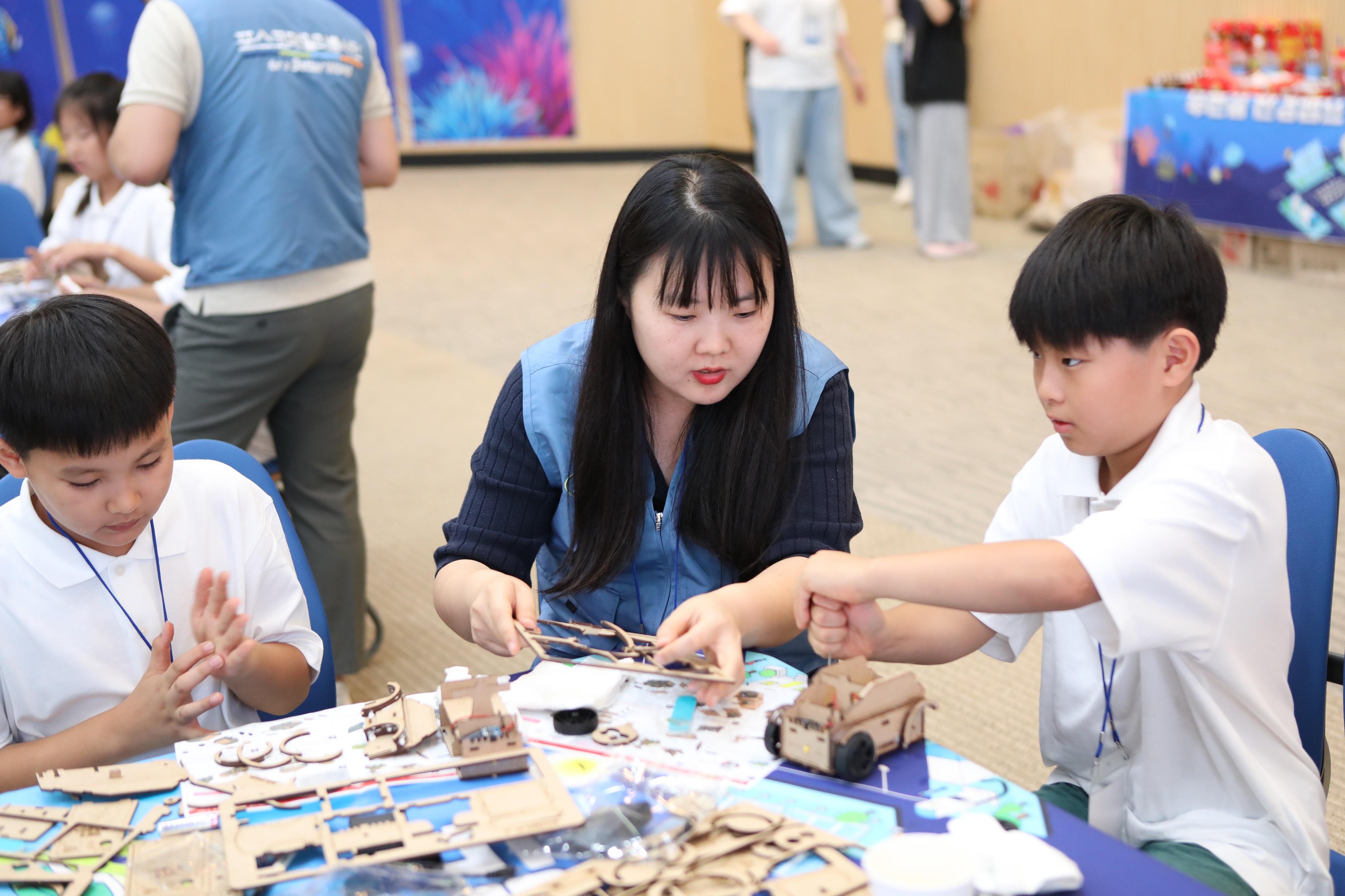 포스코퓨처엠 직원이 30일 포항 포스코 본사 대강당에서 열린 '푸른꿈 환경캠프'에 멘토로 나서 어린이와 함께 전기차 모형을 제작하고 있다.