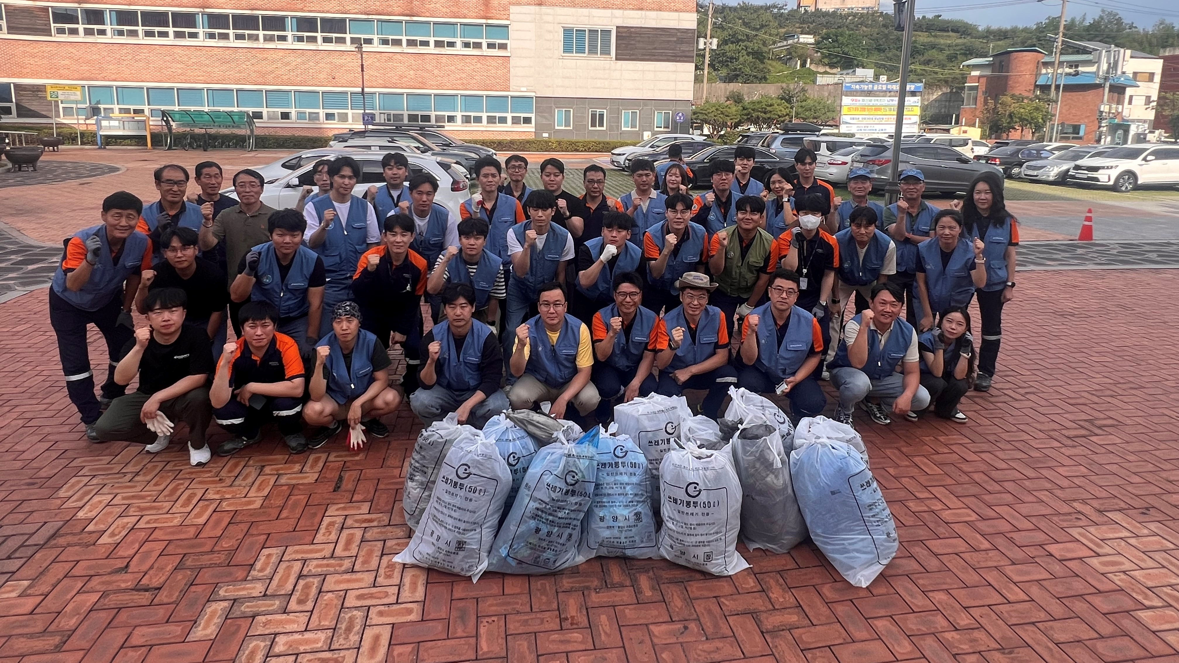 포스코퓨처엠 임직원들이 '나눔의 달'을 맞아 24일 내화물 및 라임&middot;화성 사업소가 위치한 광양 태인동에서 환경정화 활동을 마치고 기념촬영하고 있다.