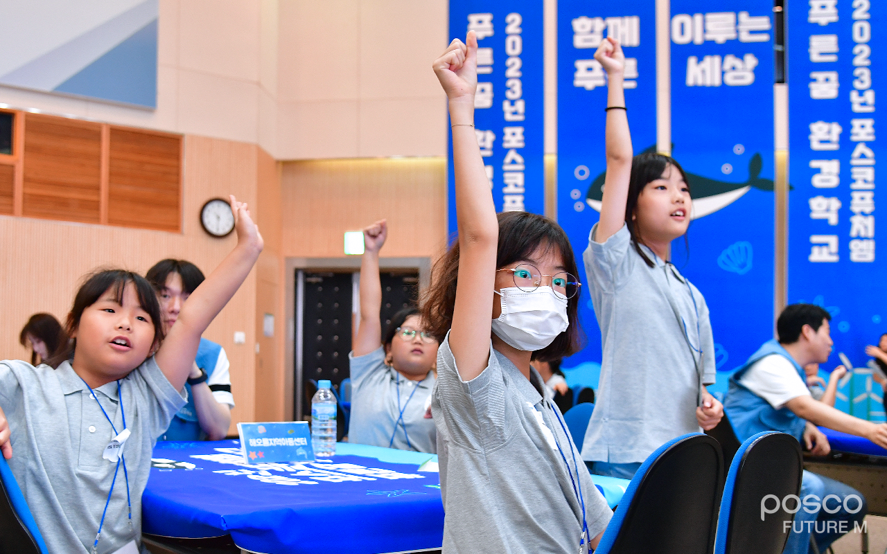 어린이들이 환경 퀴즈의 답을 맞추기 위해 손을 들고 있는 모습