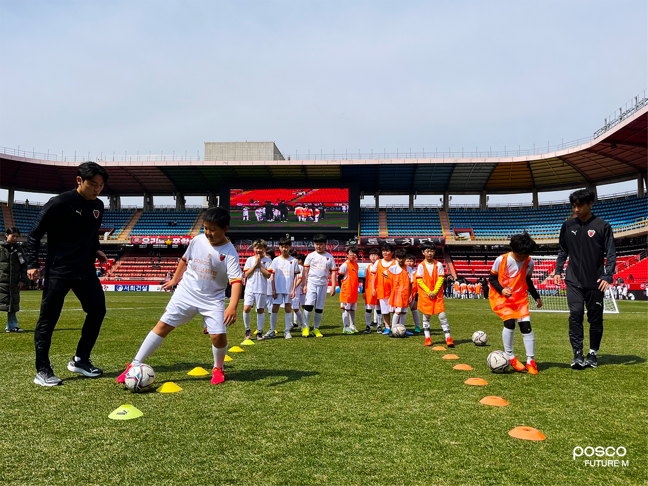 포항스틸러스 선수들이 직접 일일 코치로 나서 어린이들에게 드리블 기술을 가르쳐주고 있다.