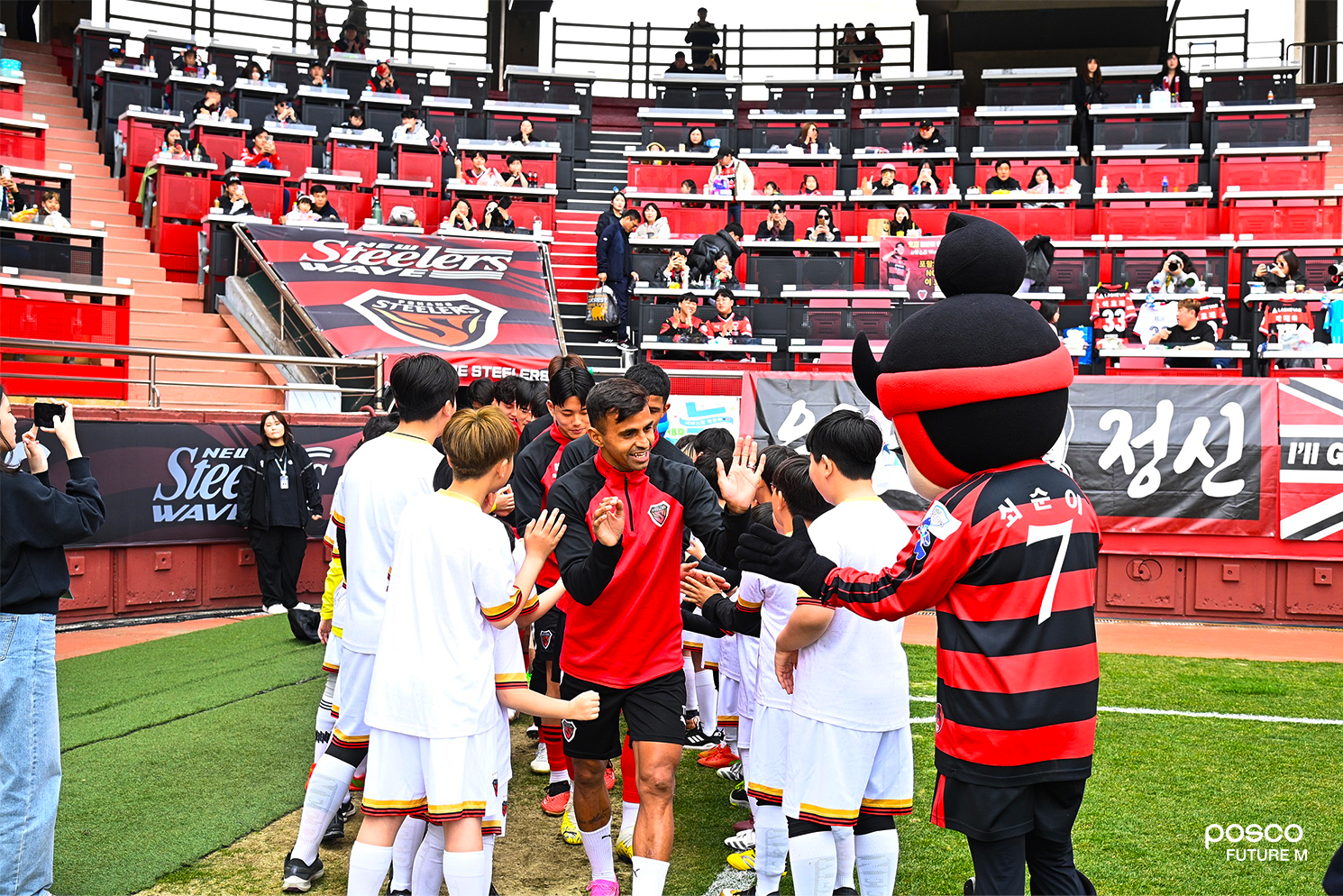 축구교실에 참여한 어린이들이 포항스틸러스 주장 완델손 선수(맨 앞) 등과 함께 하이파이브를 나누며 즐거워하고 있다.