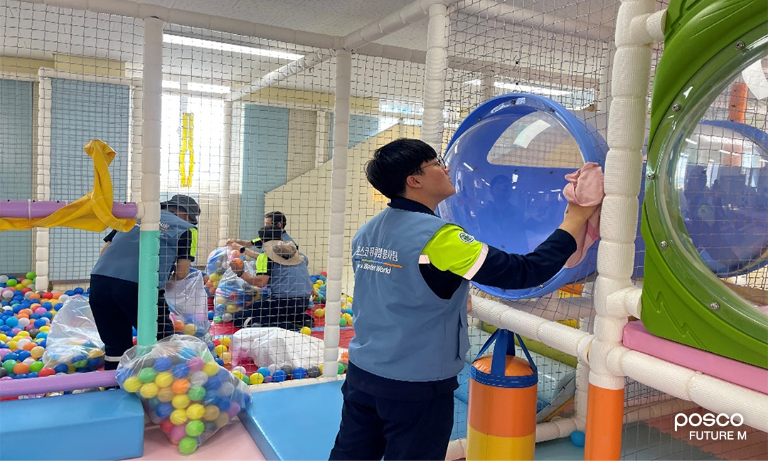 포스코퓨처엠 직원들이 지역아동센터를 방문해 실내놀이터 청소 봉사활동을 진행중인 모습