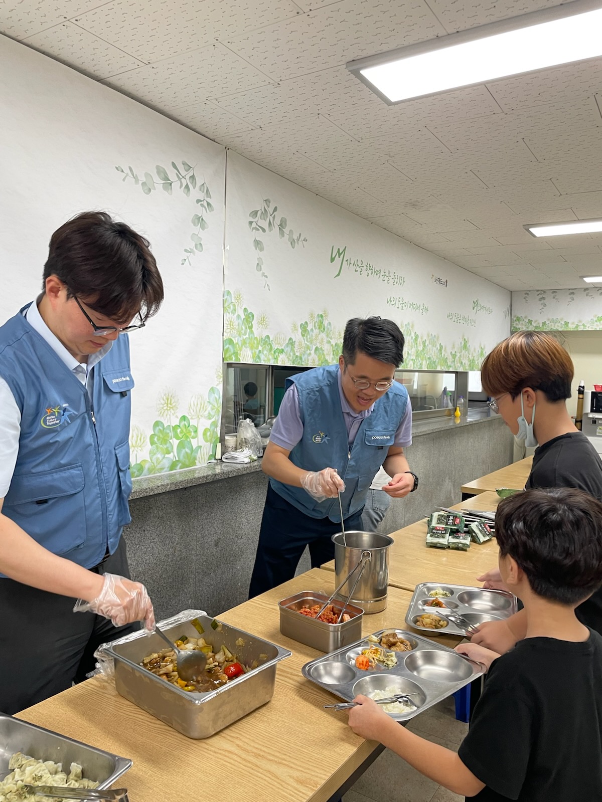 포스코퓨처엠 직원들이 지난 4일 포항시 지역아동센터에 방문해 아이들의 점심 배식을 돕고 있다.