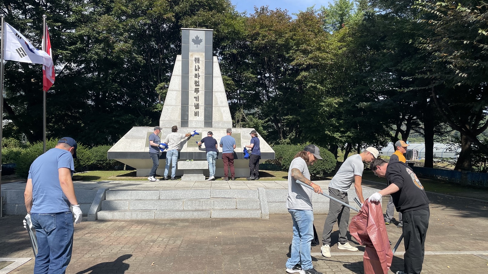 얼티엄캠 임직원들이 캐나다 전투기념비를 찾아 추모하고 환경정화 봉사활동을 하고 있다.